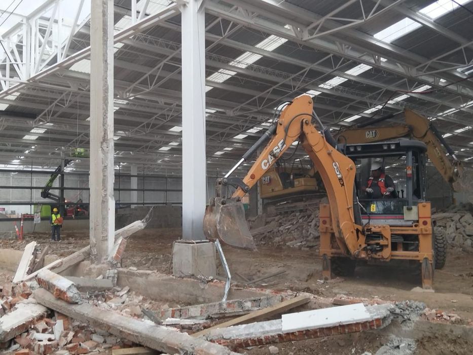 Maquinaria pesada demoliendo estructura metálica