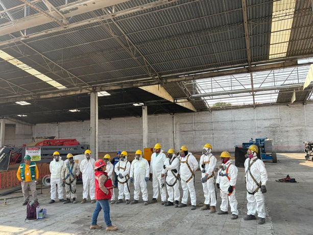 Técnico con equipo de protección inspeccionando techado