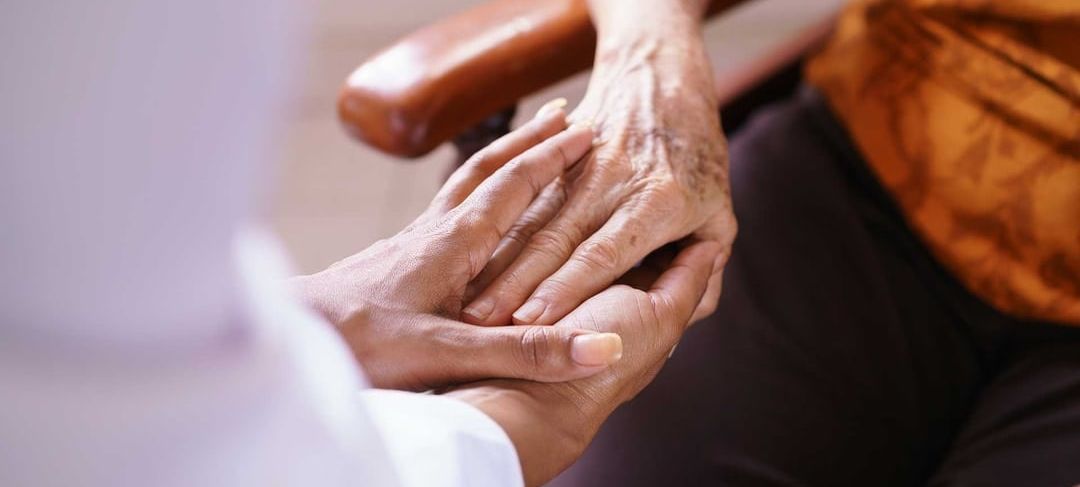 person holding the hand of an older person