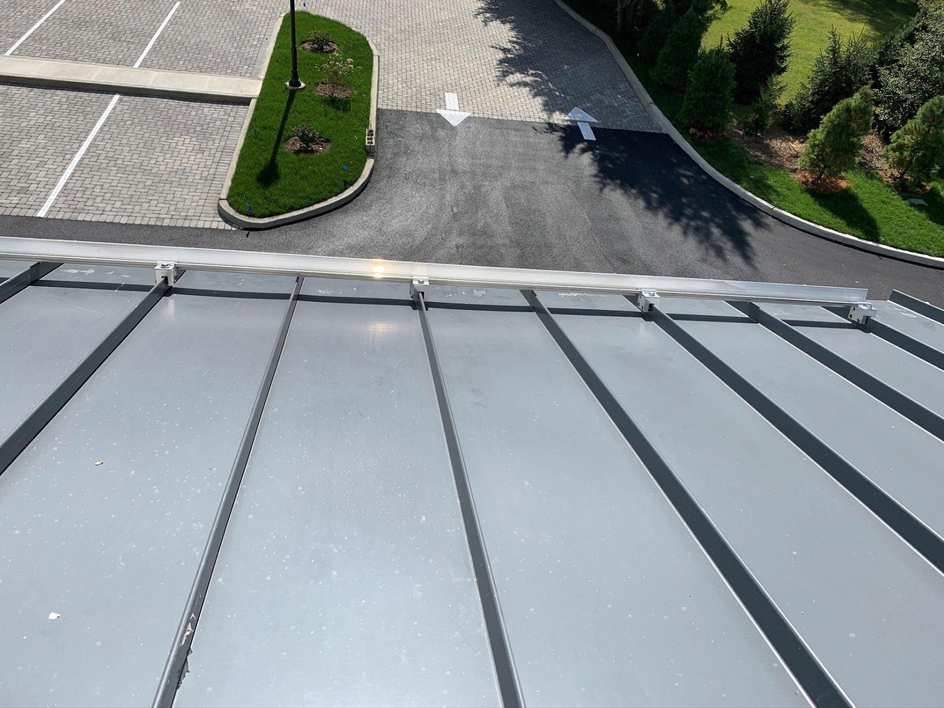 An aerial view of a roof with a parking lot in the background