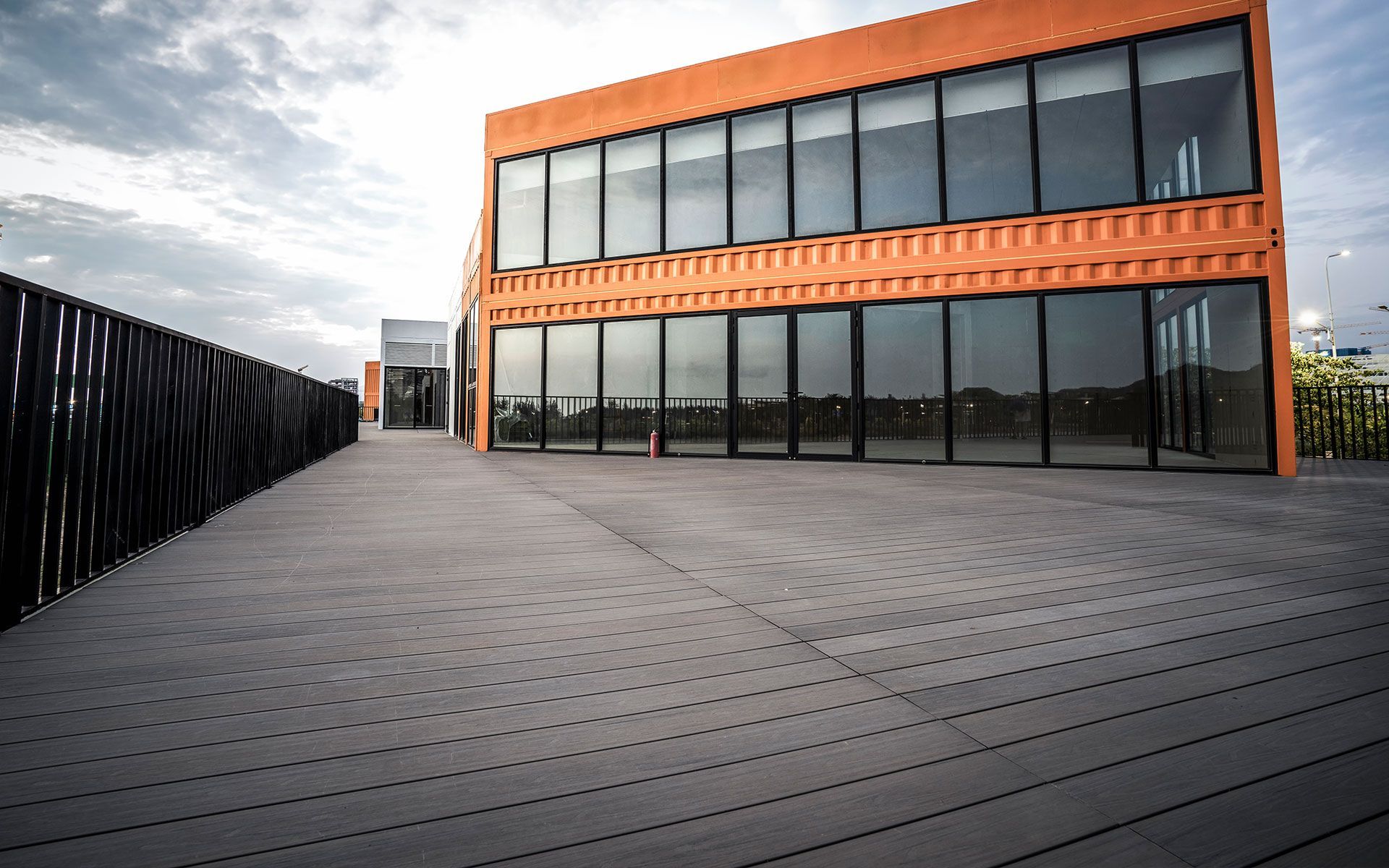 A large building with a lot of windows and a wooden deck in front of it.