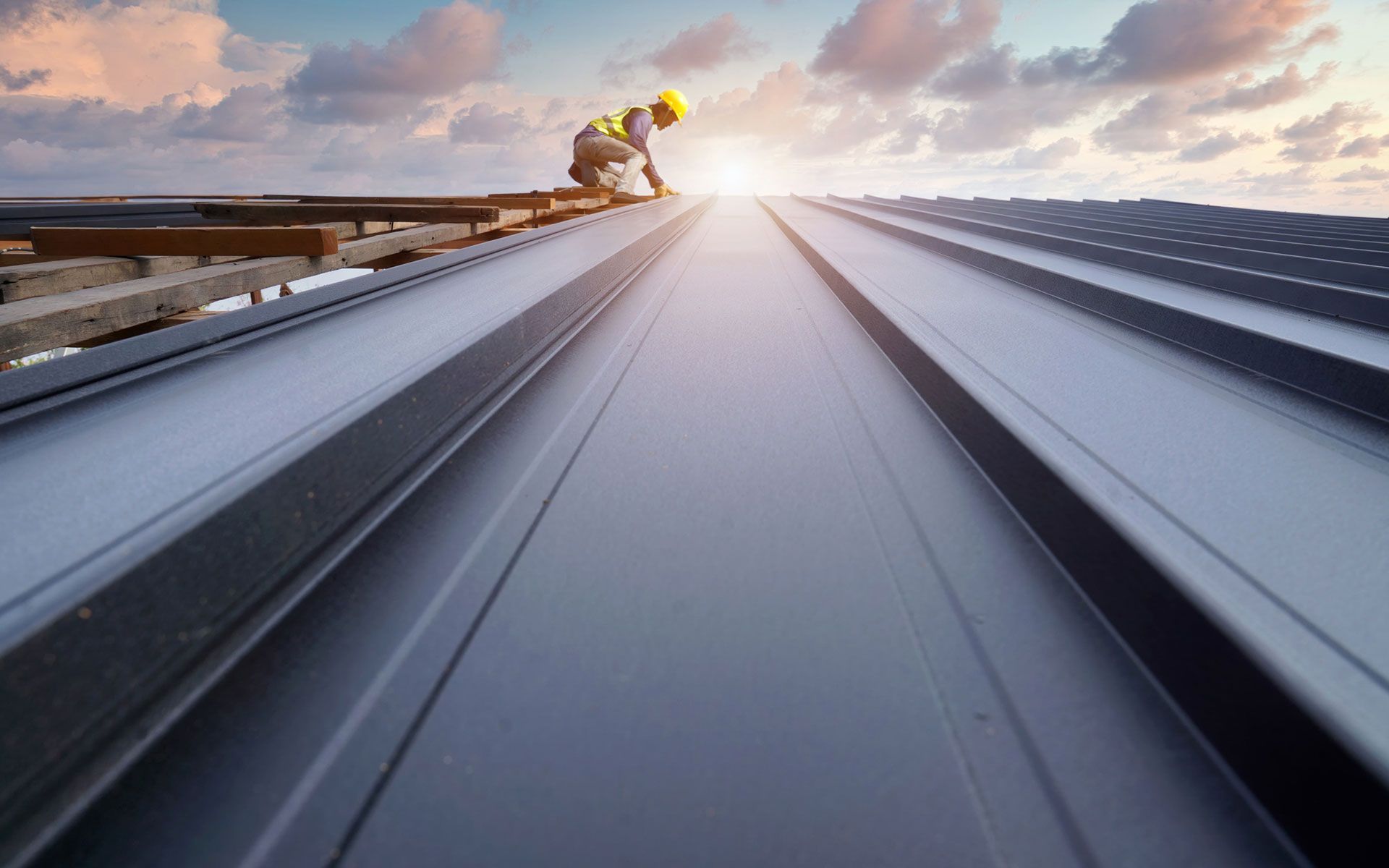 A construction worker is working on the roof of a building.