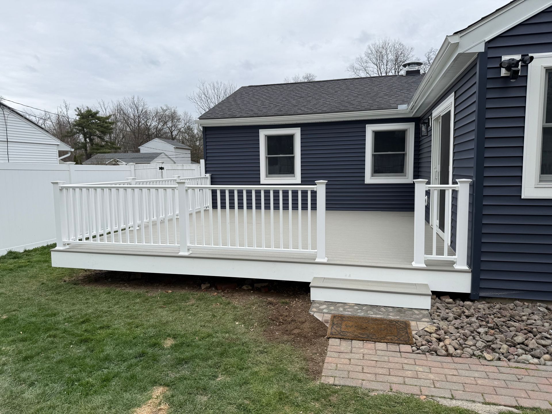 A blue house with a white deck in front of it