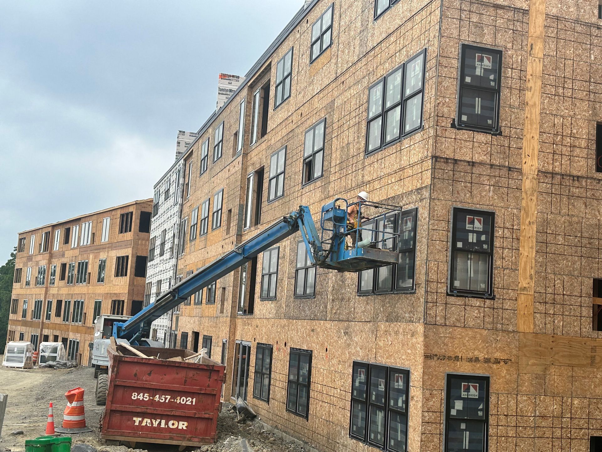 A man is cleaning the windows of a tall building.