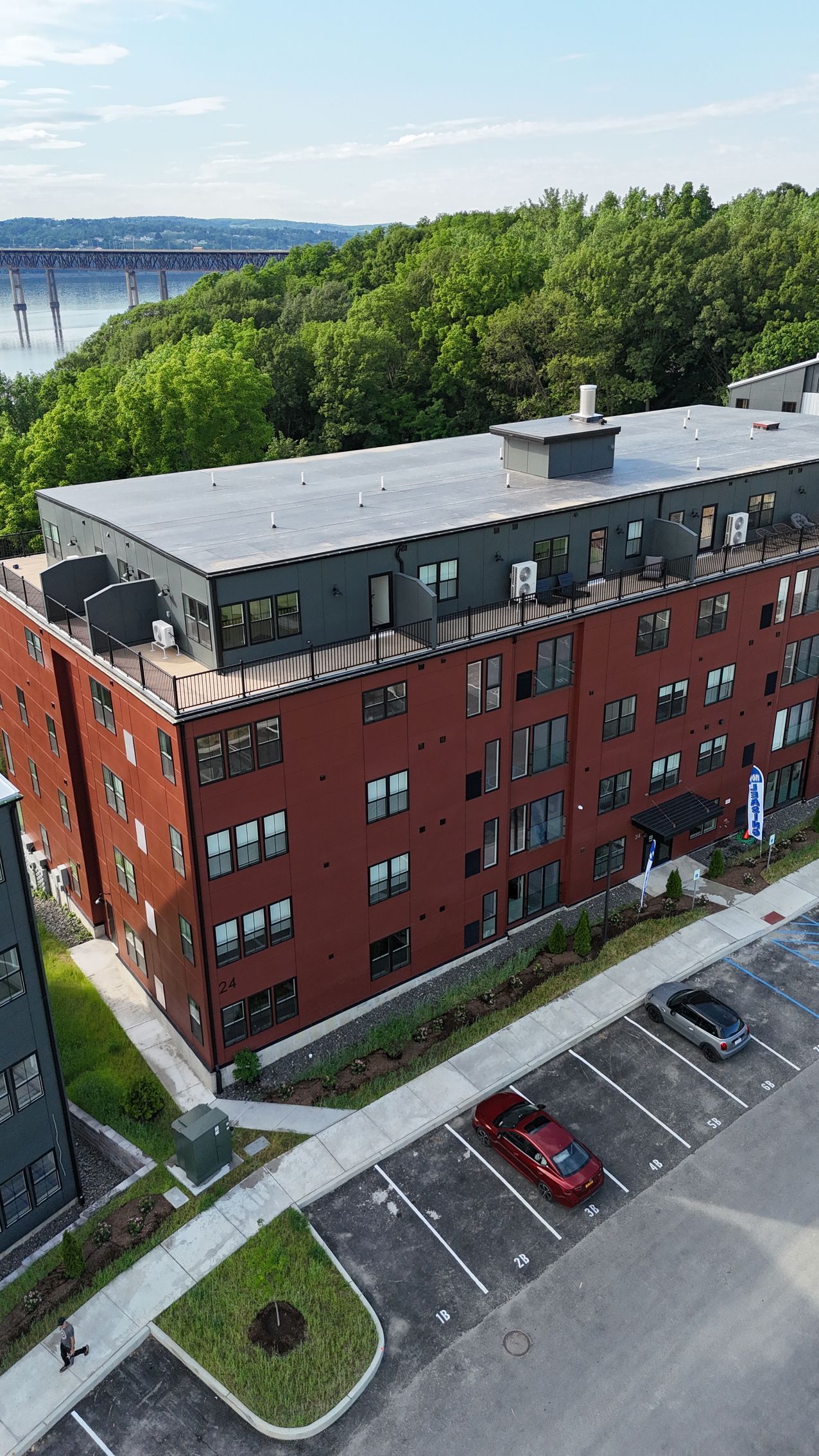 An aerial view of a large apartment building with a parking lot in front of it.