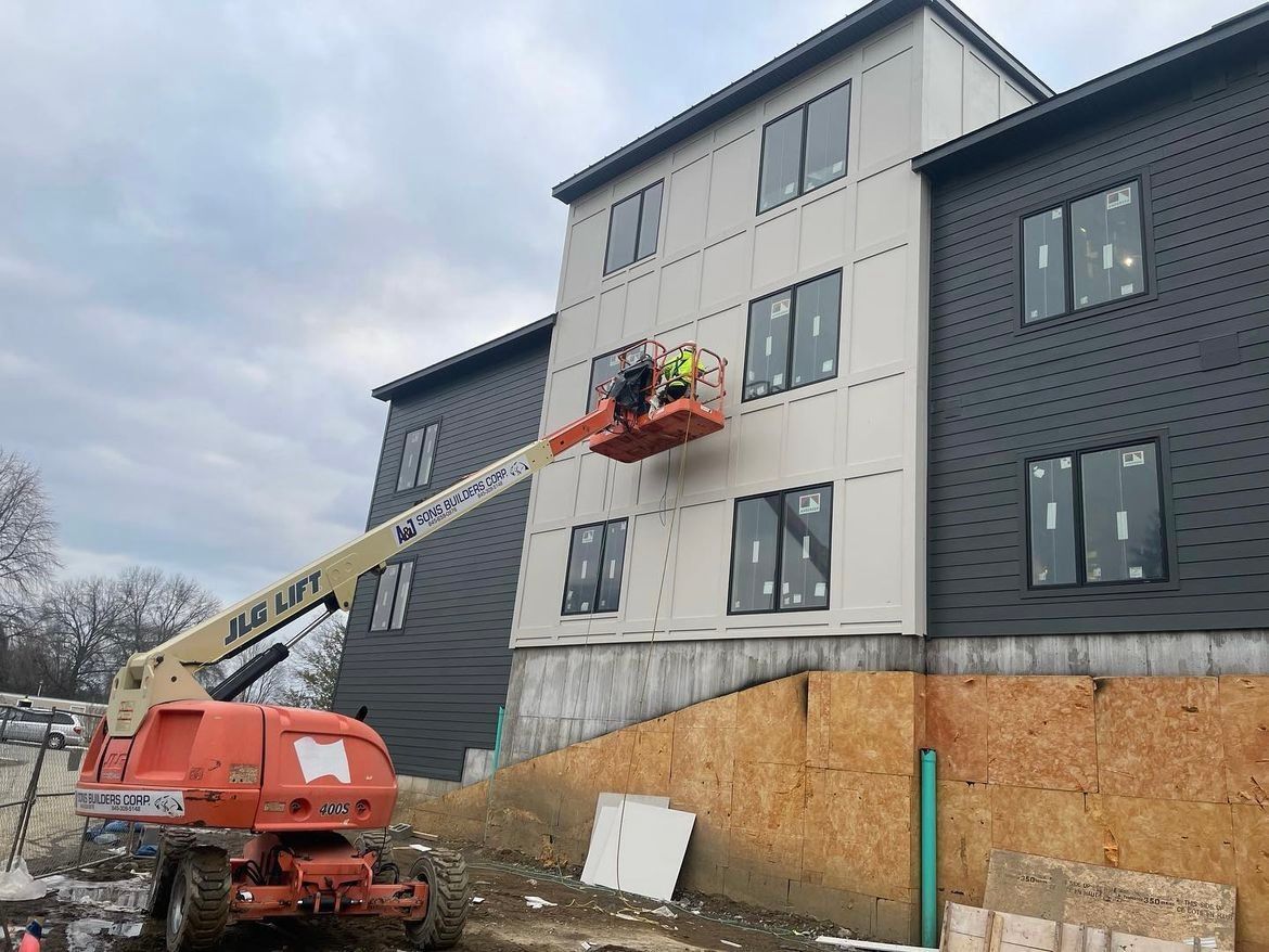 A man is working on the side of a building with a crane.