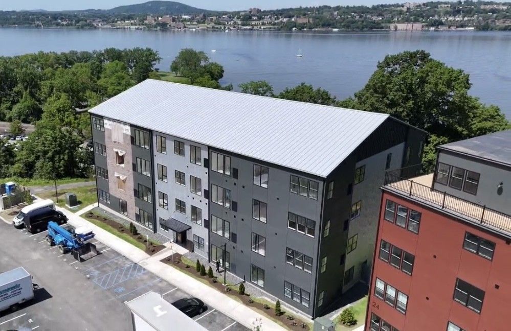 An aerial view of a building with a lake in the background