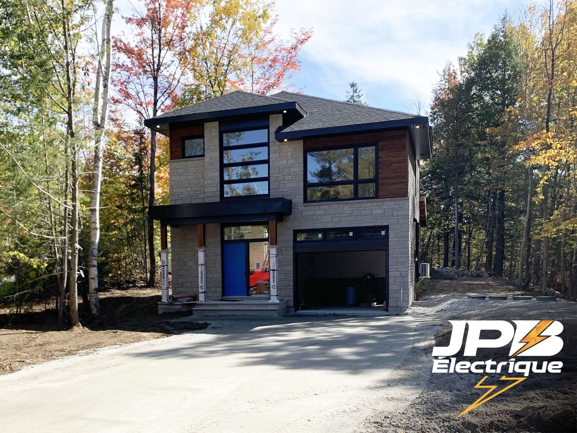 une maison en brique avec un garage et une porte bleue