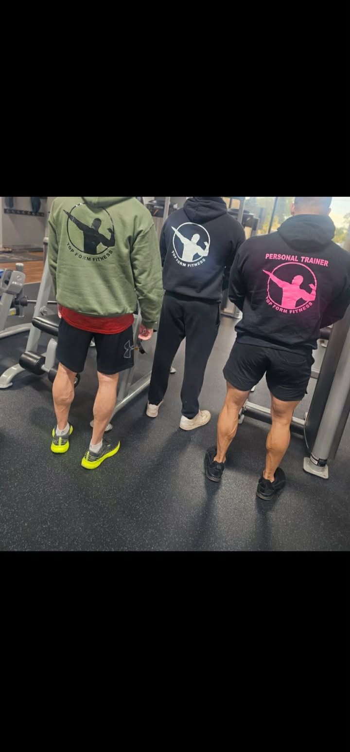 Three people walking away on a wet street, wearing hoodies and shorts, with bright neon shoes.
