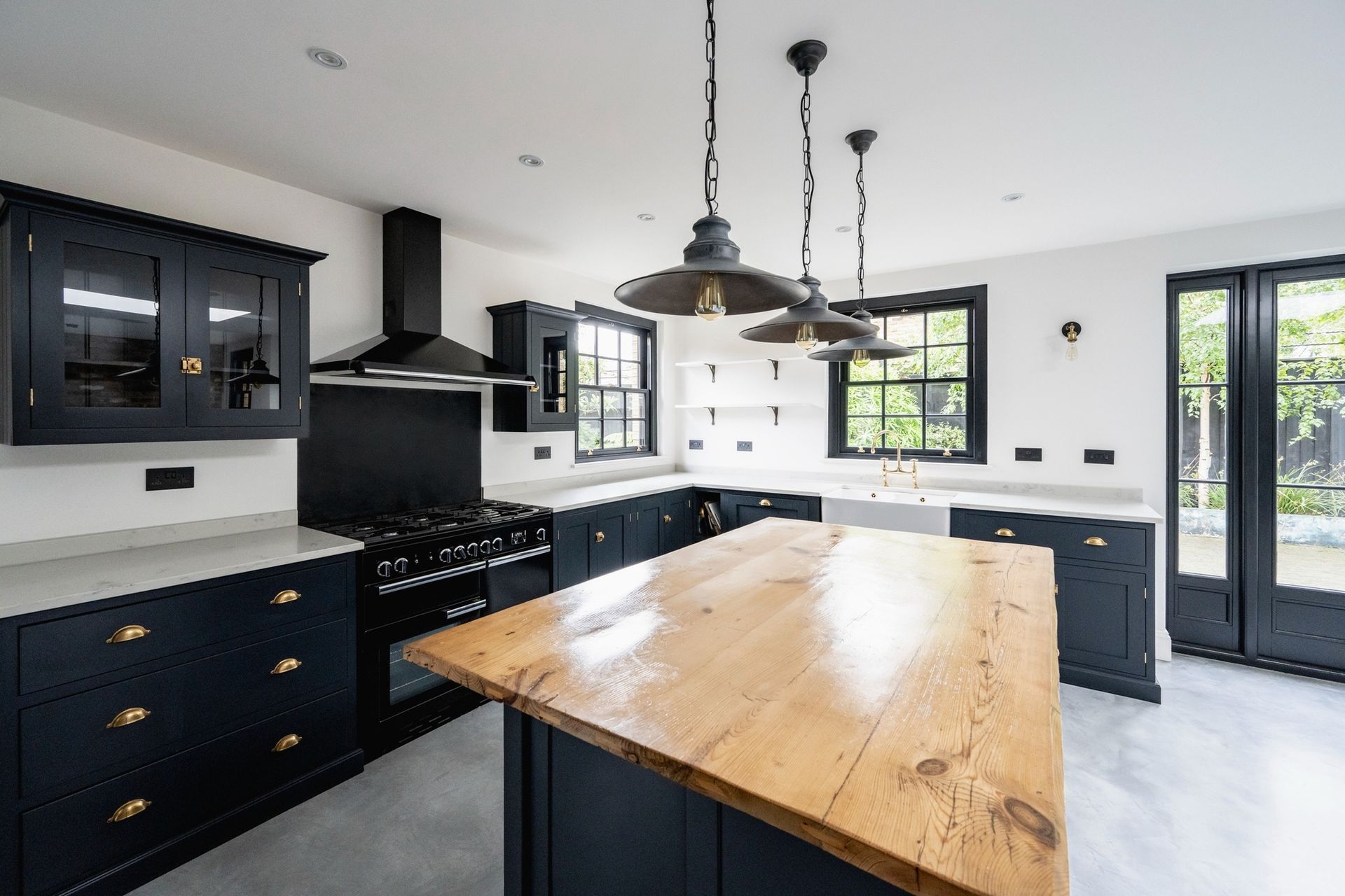 Modern black-and-white kitchen with a large wooden island and pendant lights