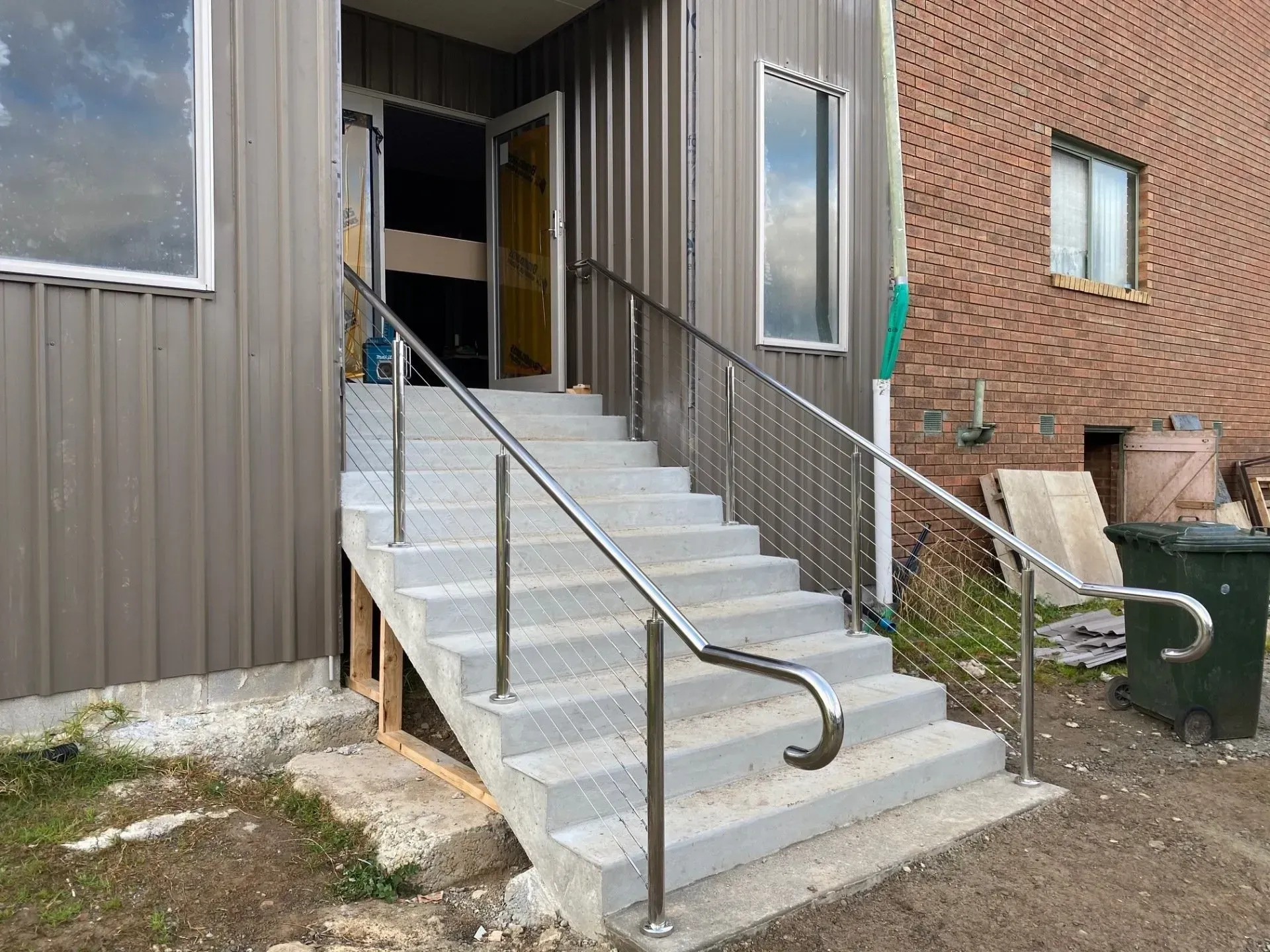 Exterior stairs with metal railings leading to a doorway on a building side