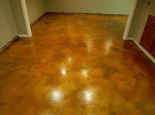 Polished amber stained concrete floor with a glossy reflective finish.