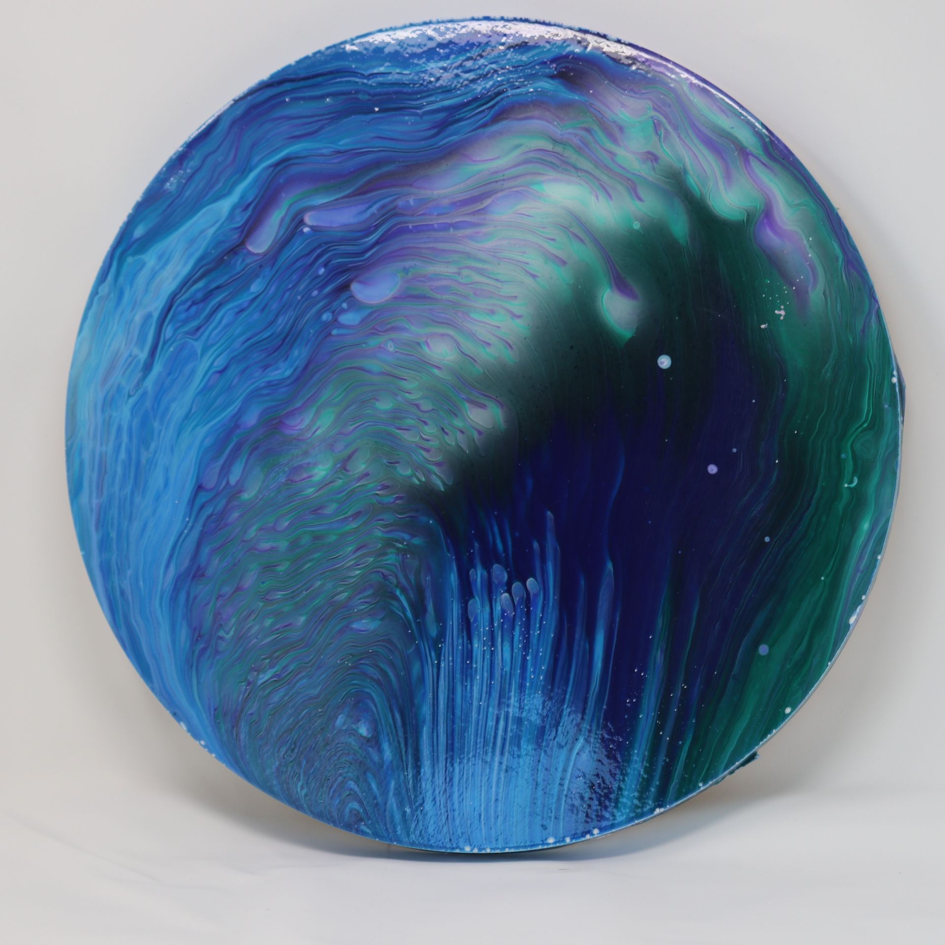 Abstract blue and teal swirling sphere with a dark central cavity on a light background