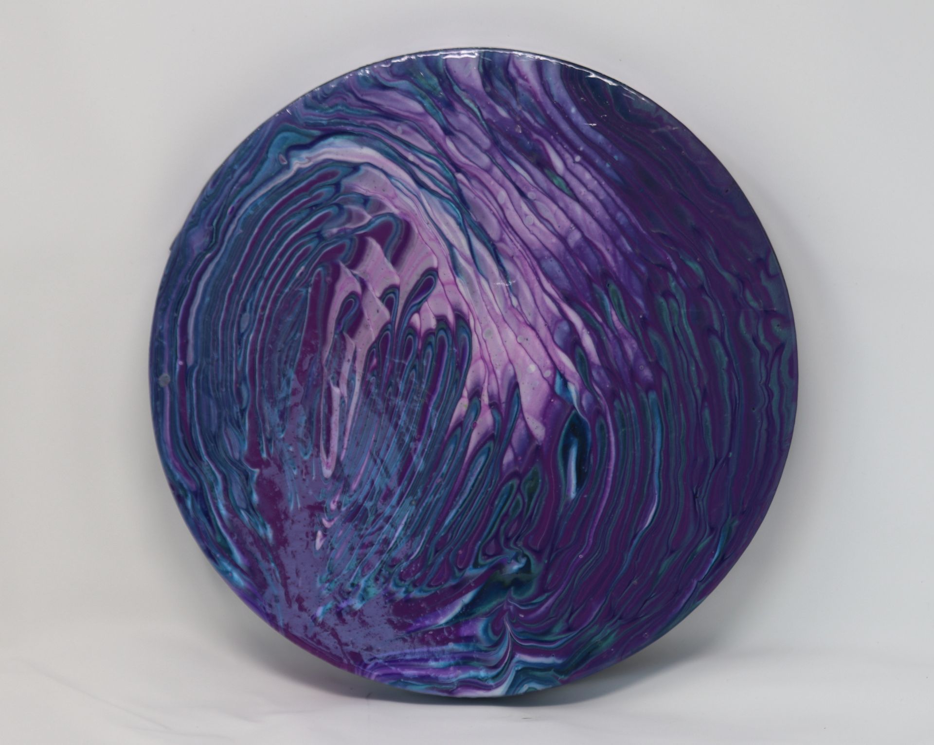 Purple and blue marbled yarn ball on a light gray background