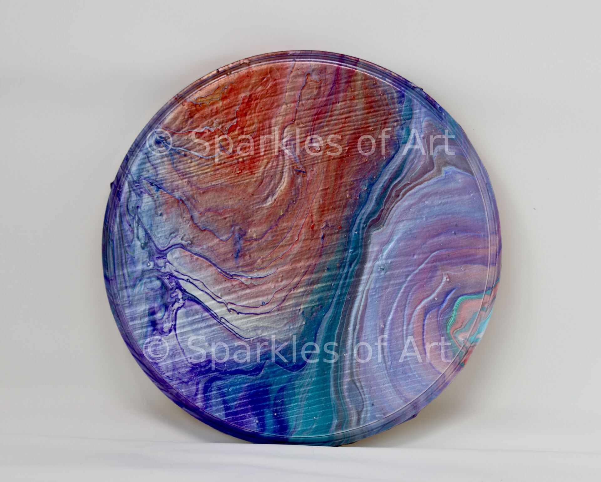 Round abstract painting with swirling blue, purple, and red marbled colors
