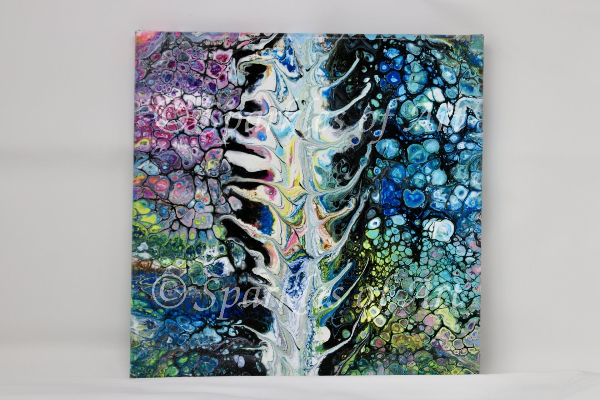 Abstract multicolor painting with a white tree-like center on a black, blue, pink, and yellow textured background