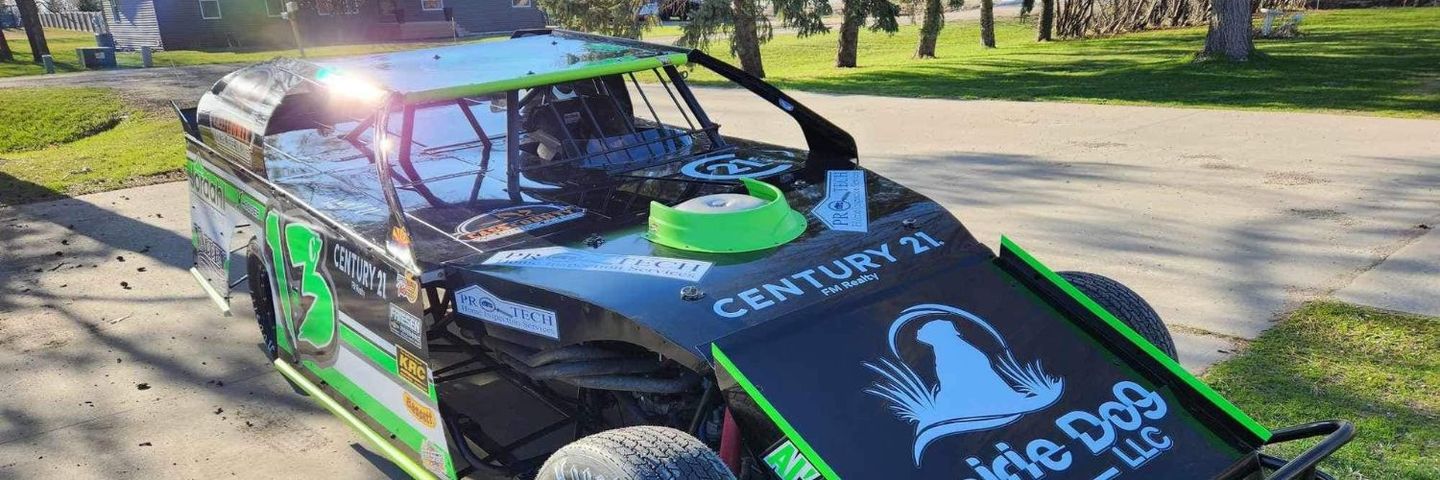 A black and green buggy is parked on the side of a road.