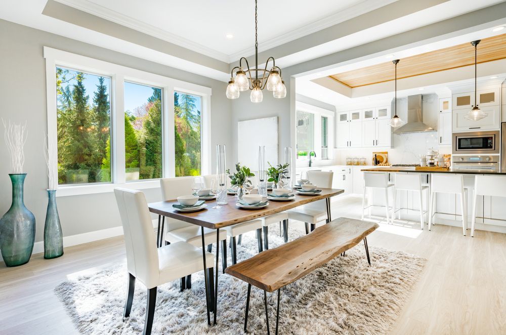 A dining room with a table and chairs and a bench.