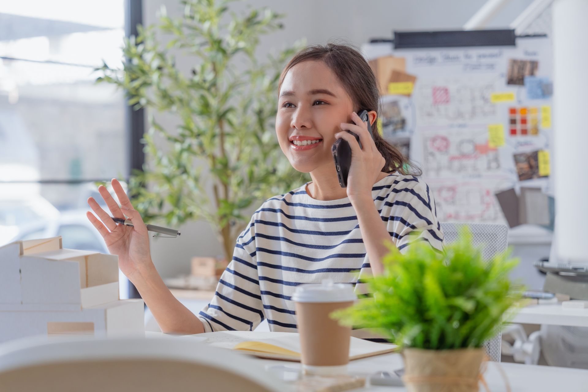 An interior designer is talking on a cell phone with a custom furniture manufacturer