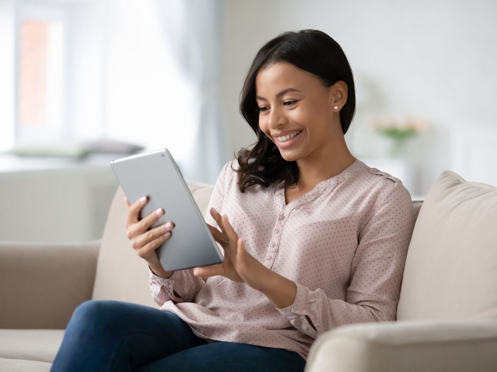 Woman smiling and reading on a tablet
