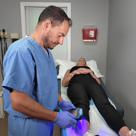A man with an IV in his arm is using a cell phone
