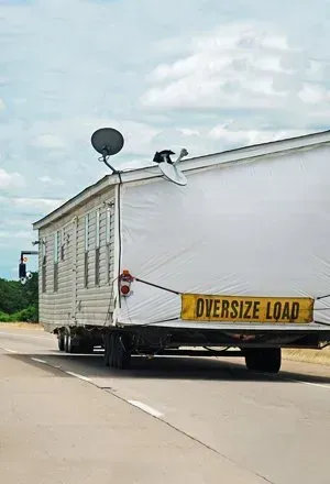 Mobile home being transported on a highway, marked with an 