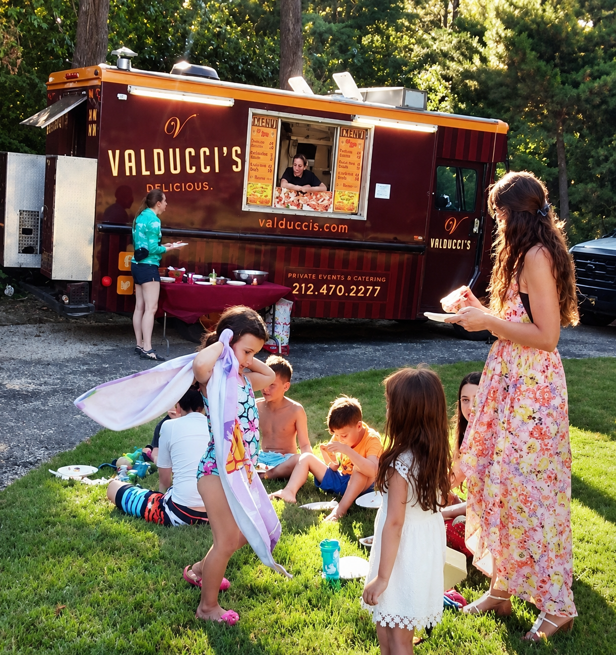 Children gathering at a food truck in a sunny park, with a woman in a floral dress nearby.
