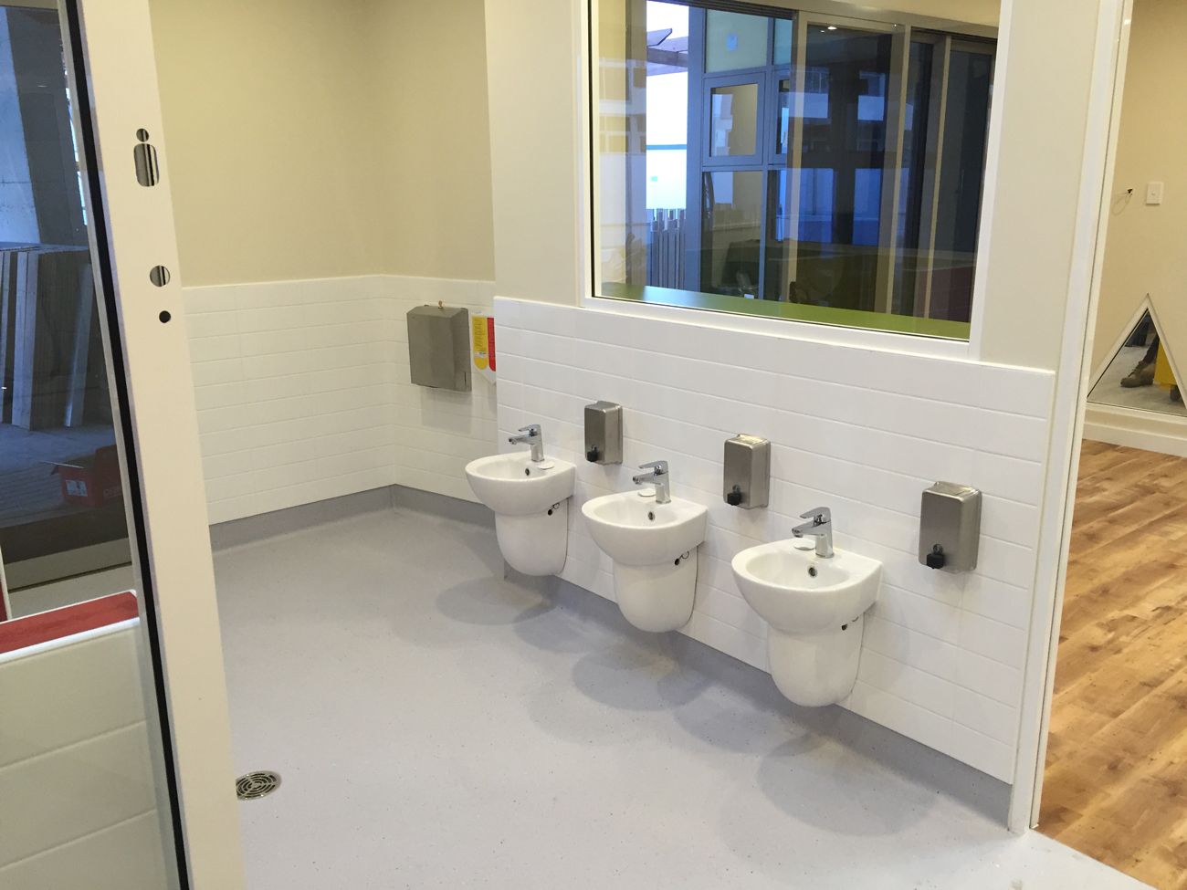 A bathroom with a row of sinks and a mirror