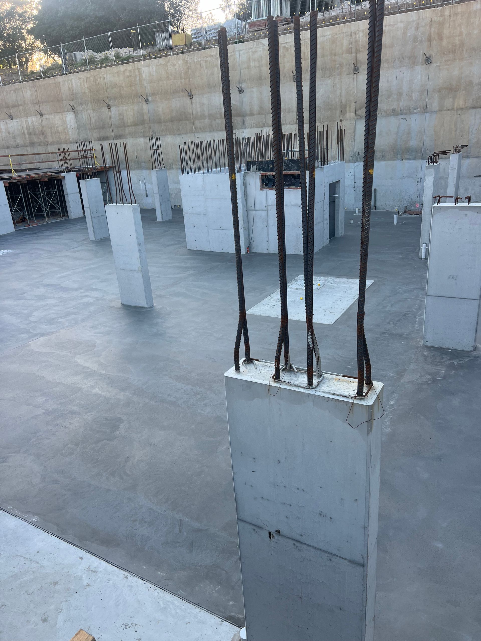 Concrete foundation with reinforced steel bars, construction site.