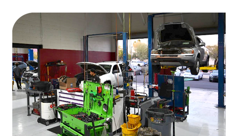 A car is sitting on a lift in a garage.