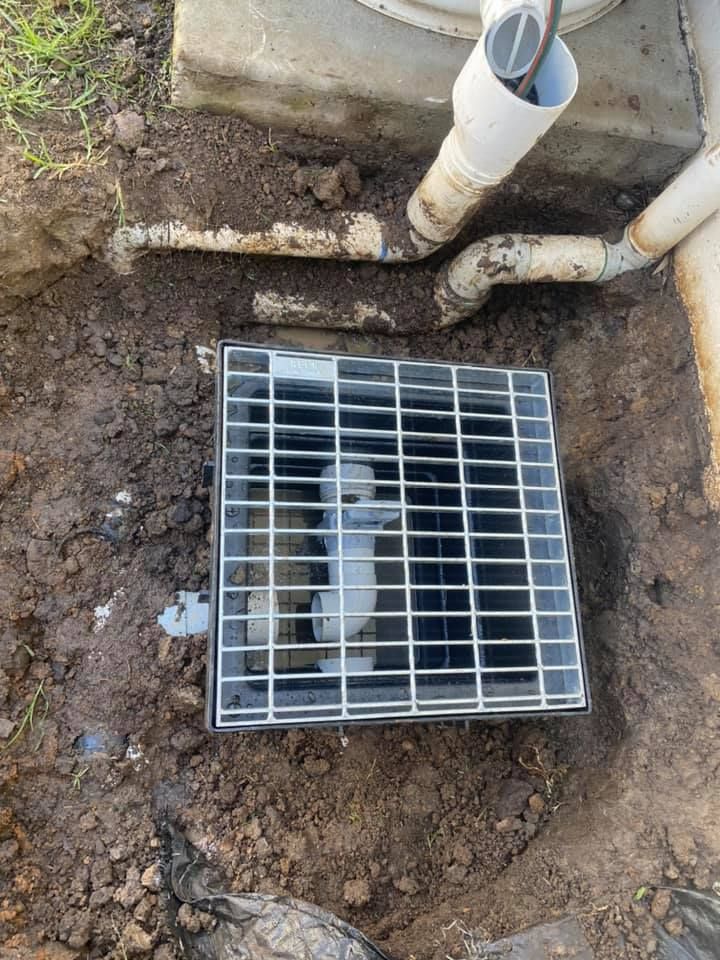 Open Drain With Metal Grate in a Muddy Outdoor Area — Medowie Plumbing & Gas in in Newcastle
