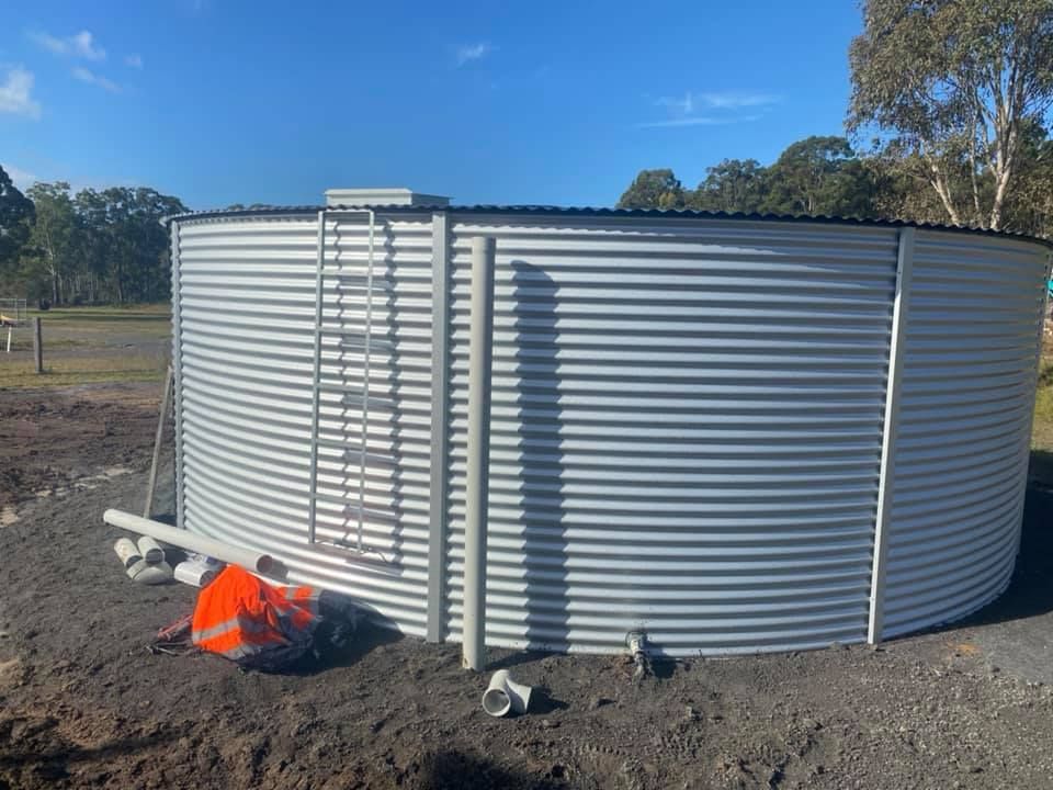 Large Silver Water Tank on a Dirt Site — Medowie Plumbing & Gas In Medowie, NSW