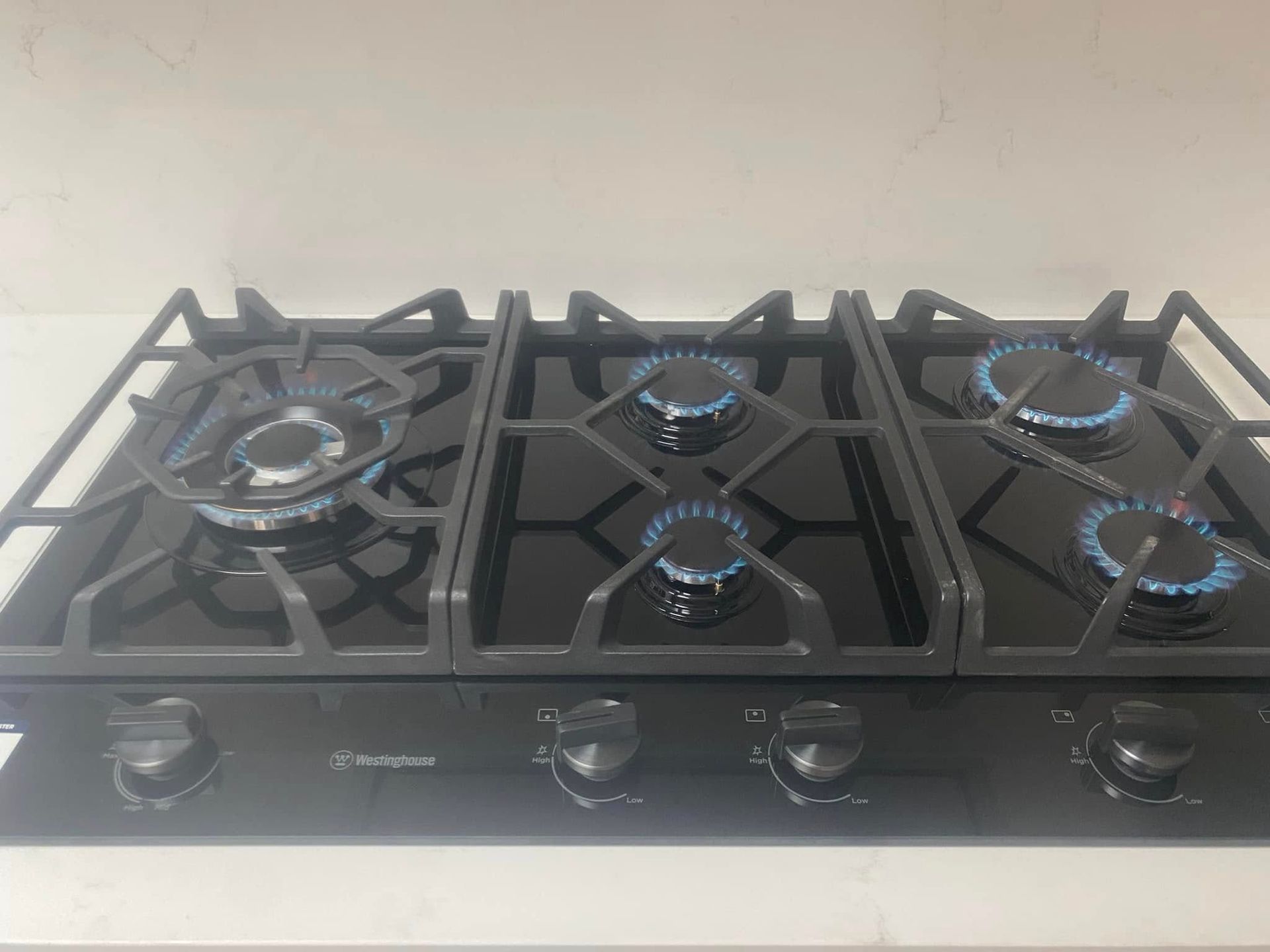 Stainless Steel Gas Cooktop With Five Burners and Black Grates — Medowie Plumbing & Gas in in Newcastle