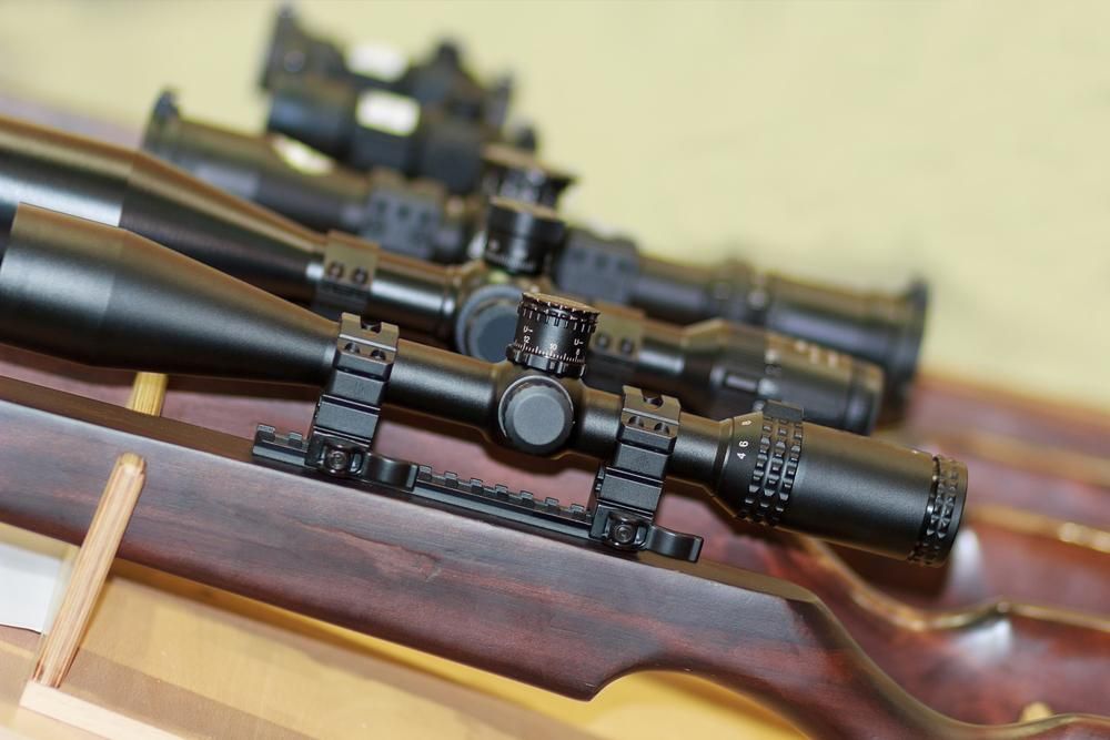 A Display Featuring Several Rifles and Binoculars — Coffs Coast Firearms In Coffs Harbour, NSW