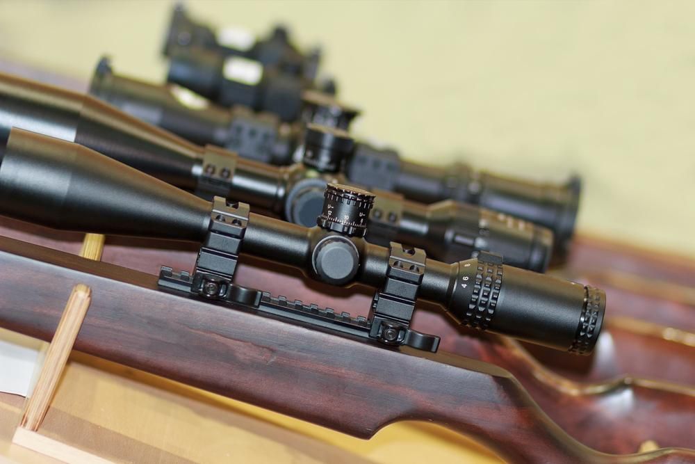 A Display Featuring Several Rifles and Binoculars — Coffs Coast Firearms In Coffs Harbour, NSW