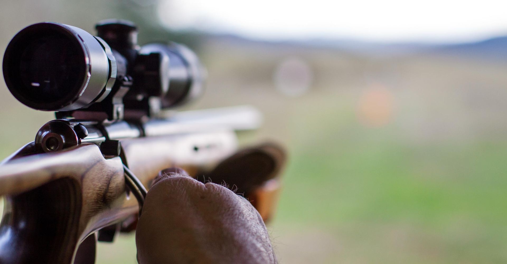 A Person Stands Holding a Scoped Rifle — Coffs Coast Firearms In Inverell, NSW