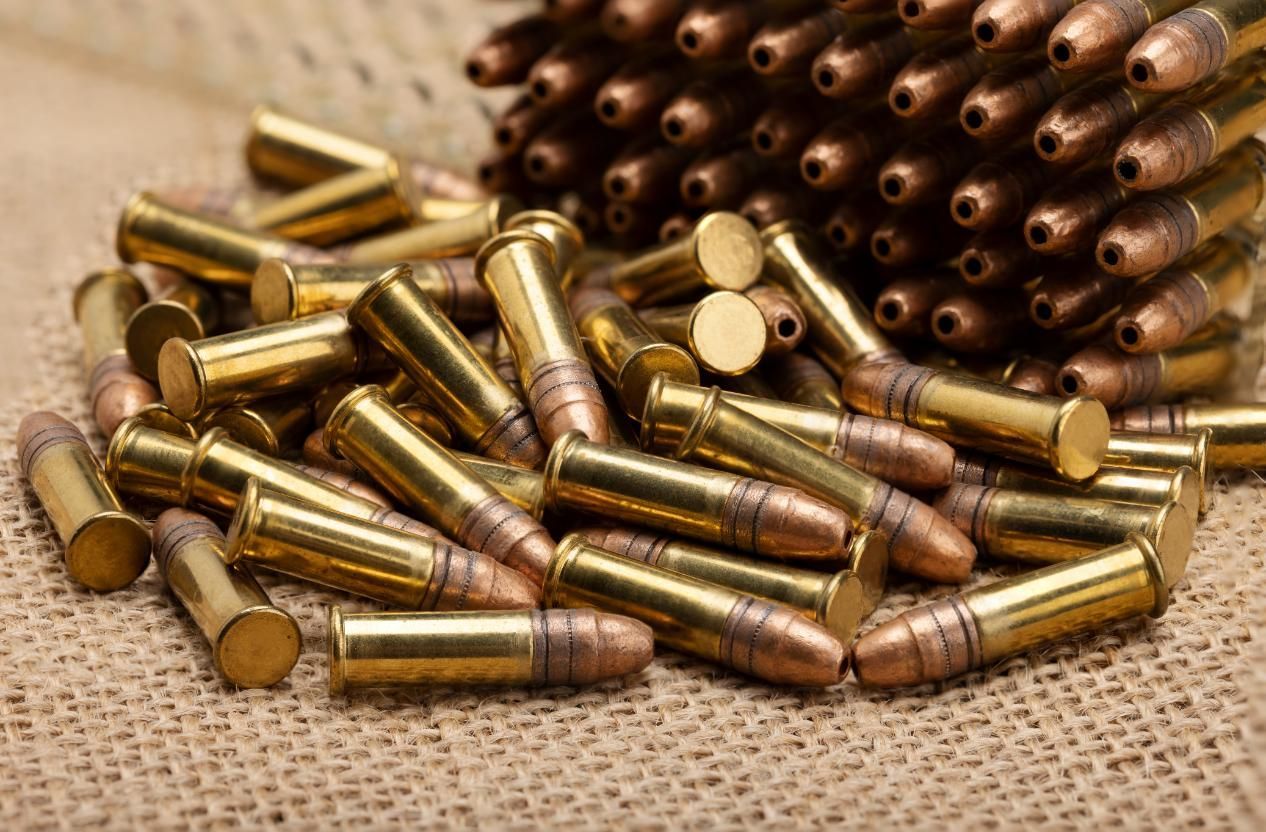 A Table Displaying Various Bullets and a Pile of Brass Casings — Coffs Coast Firearms In Coffs Harbour, NSW