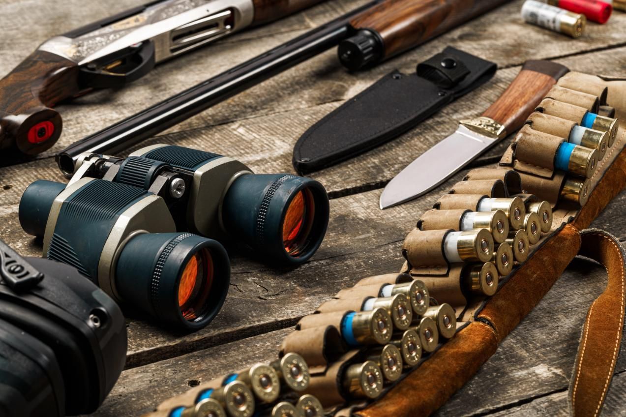 A Wooden Table Displaying Various Hunting Equipment — Coffs Coast Firearms In Coffs Harbour, NSW