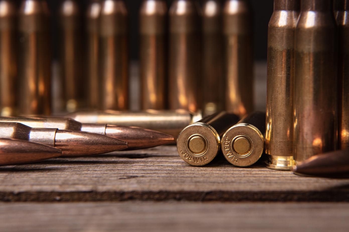 A Detailed View of Multiple Bullets Scattered on a Wooden Table — Coffs Coast Firearms In Coffs Harbour, NSW