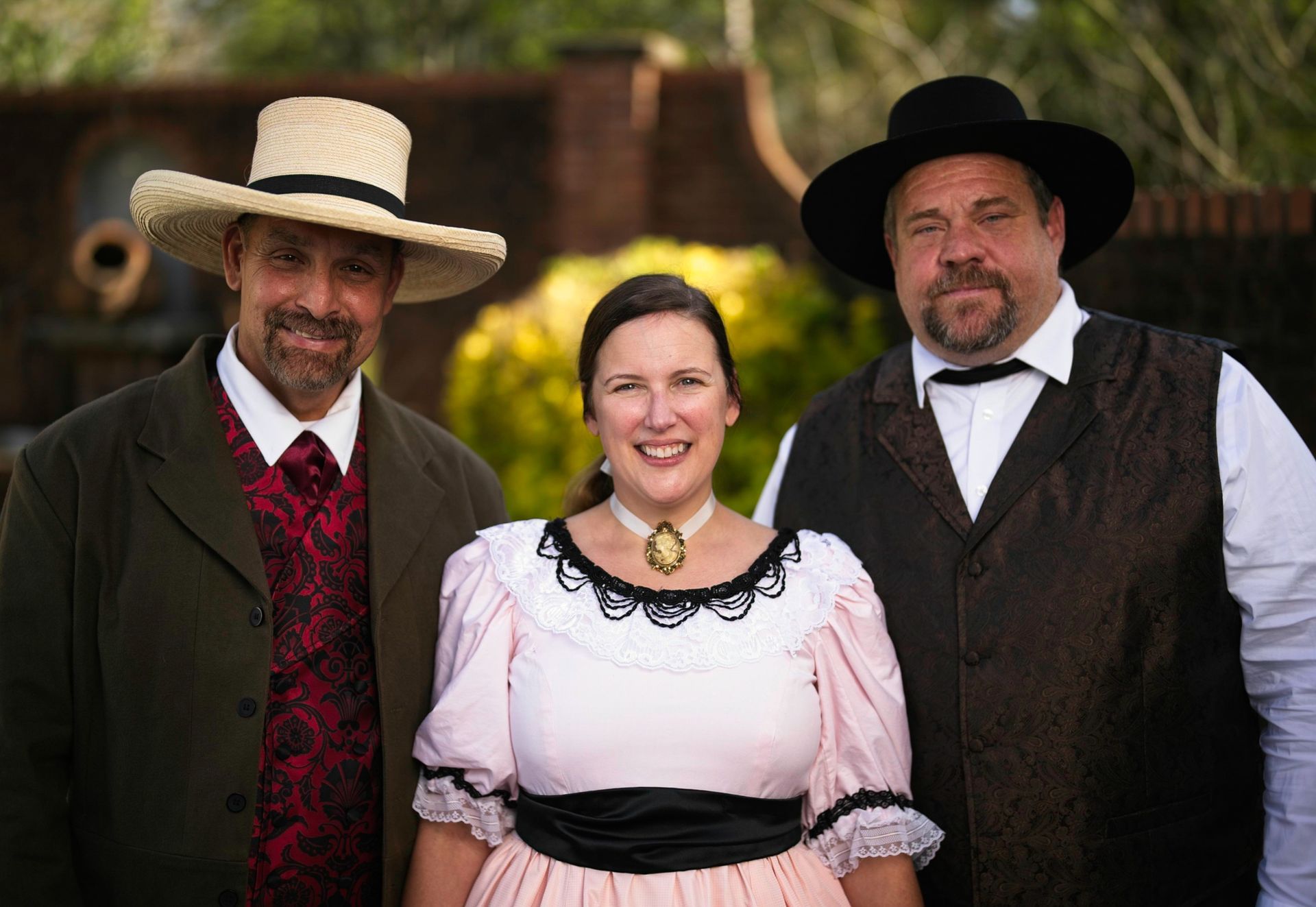A man in a straw hat is standing next to a woman in a pink dress.