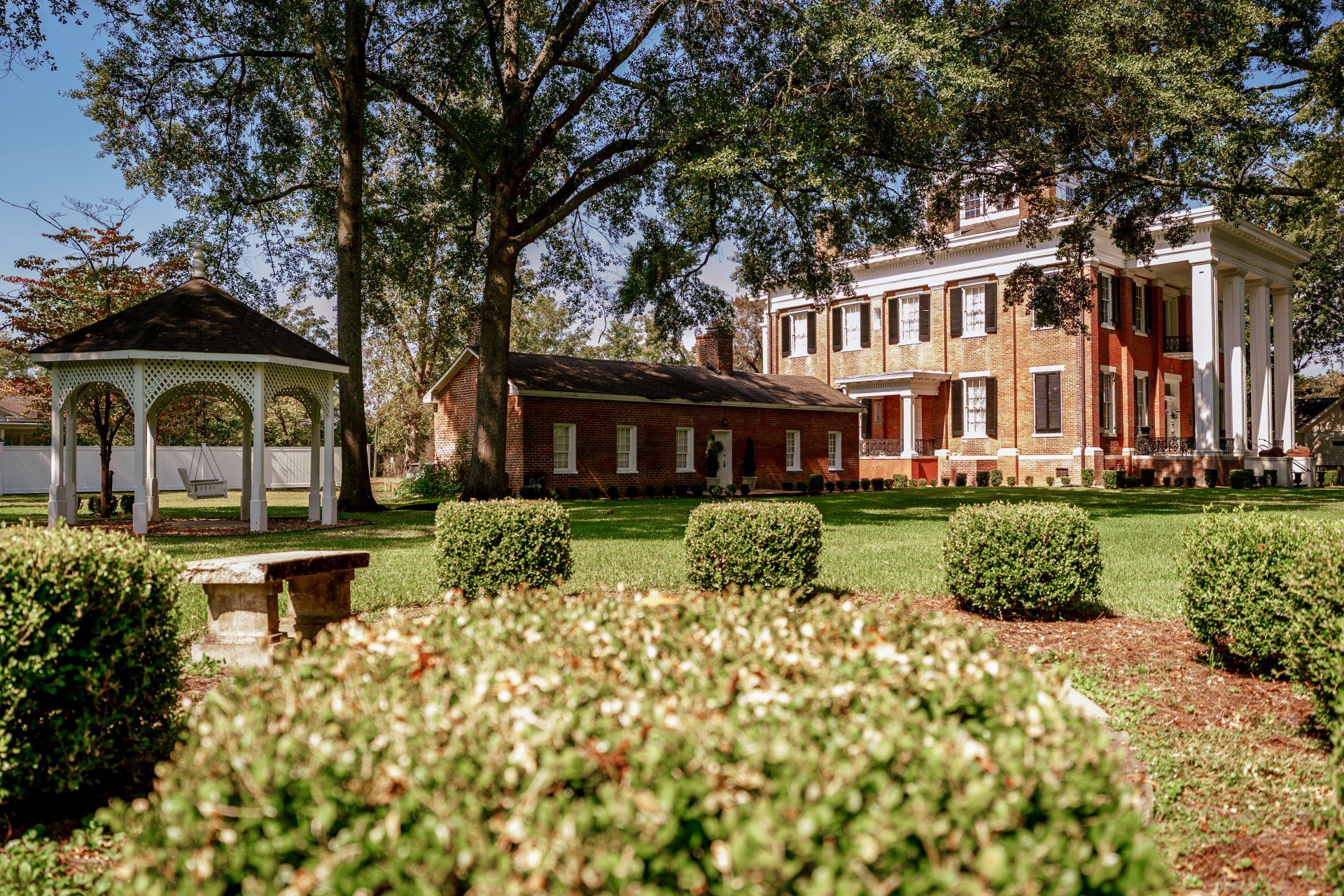 A large brick building with a gazebo in front of it.
