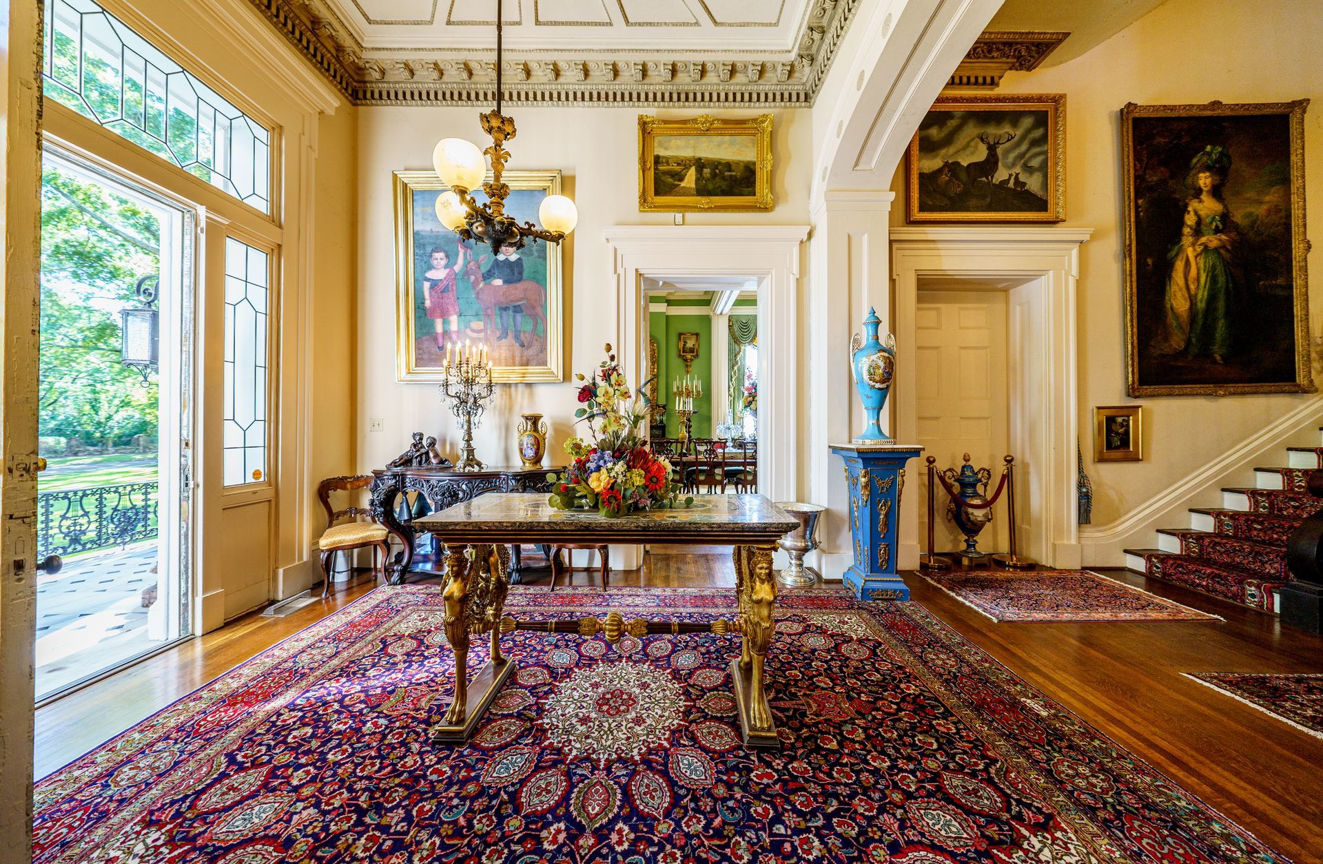 There is a table in the middle of the room with a rug on the floor.