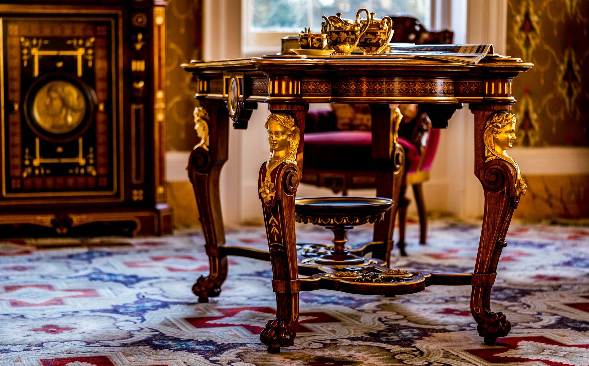 A table with a clock on it is sitting on a rug in a room.