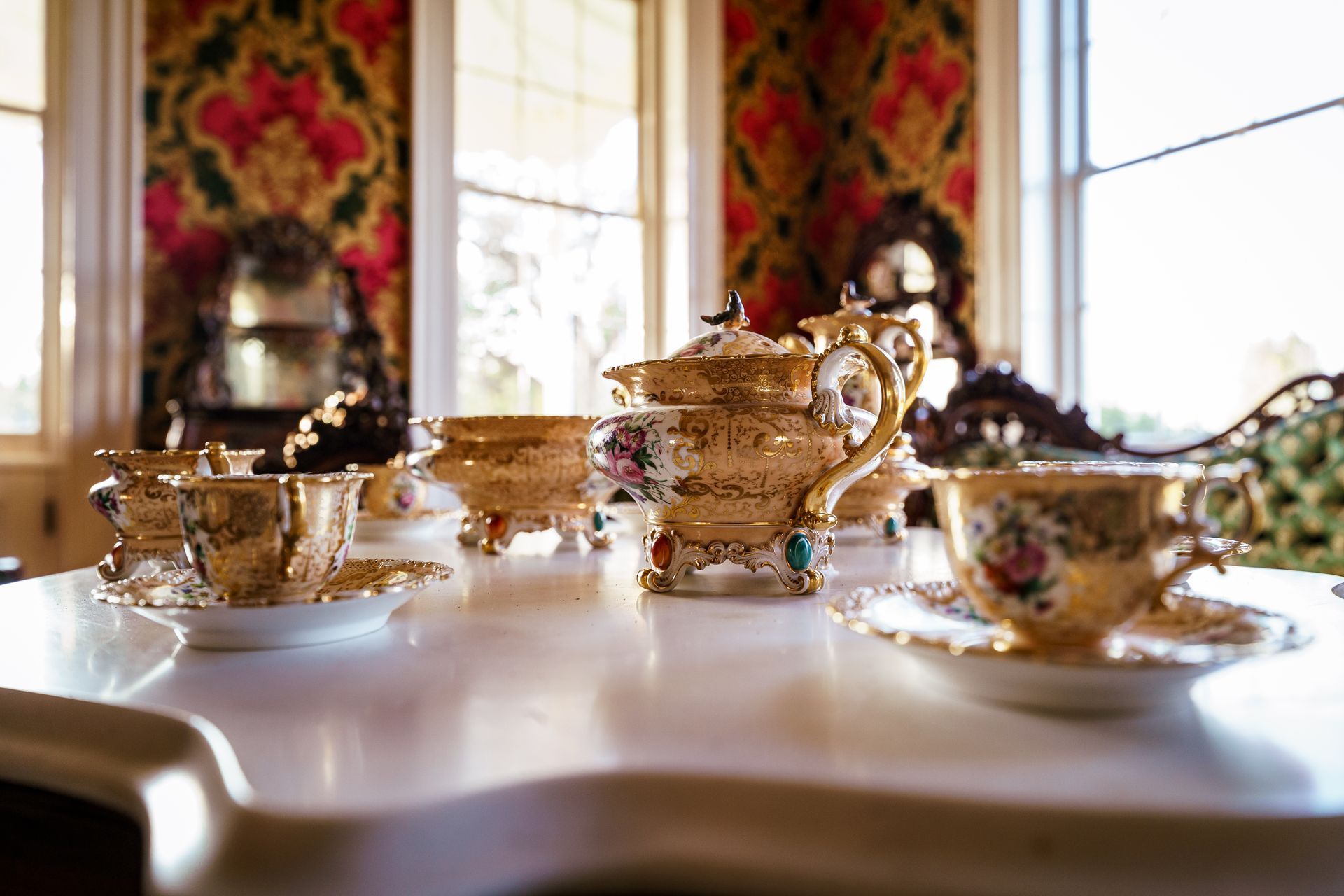 There are many cups and saucers on the table.