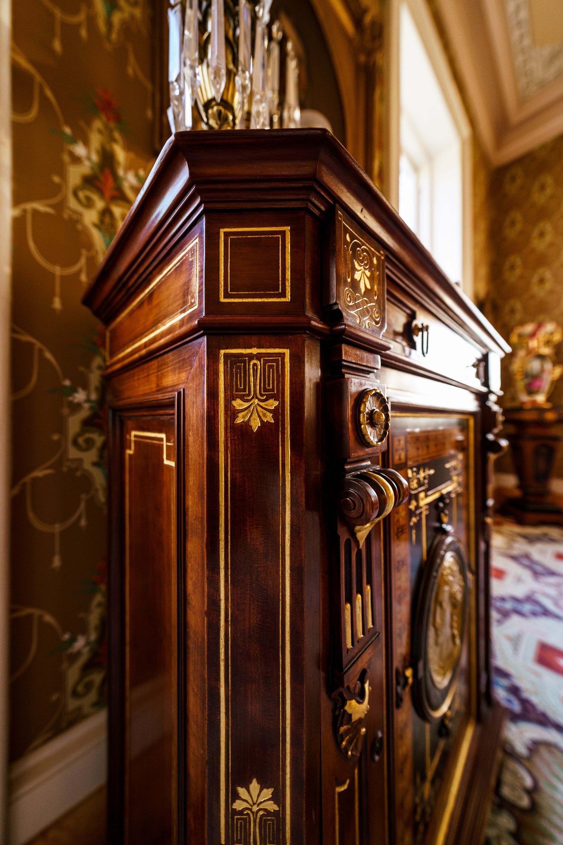 A close up of a wooden cabinet with gold trim in a room