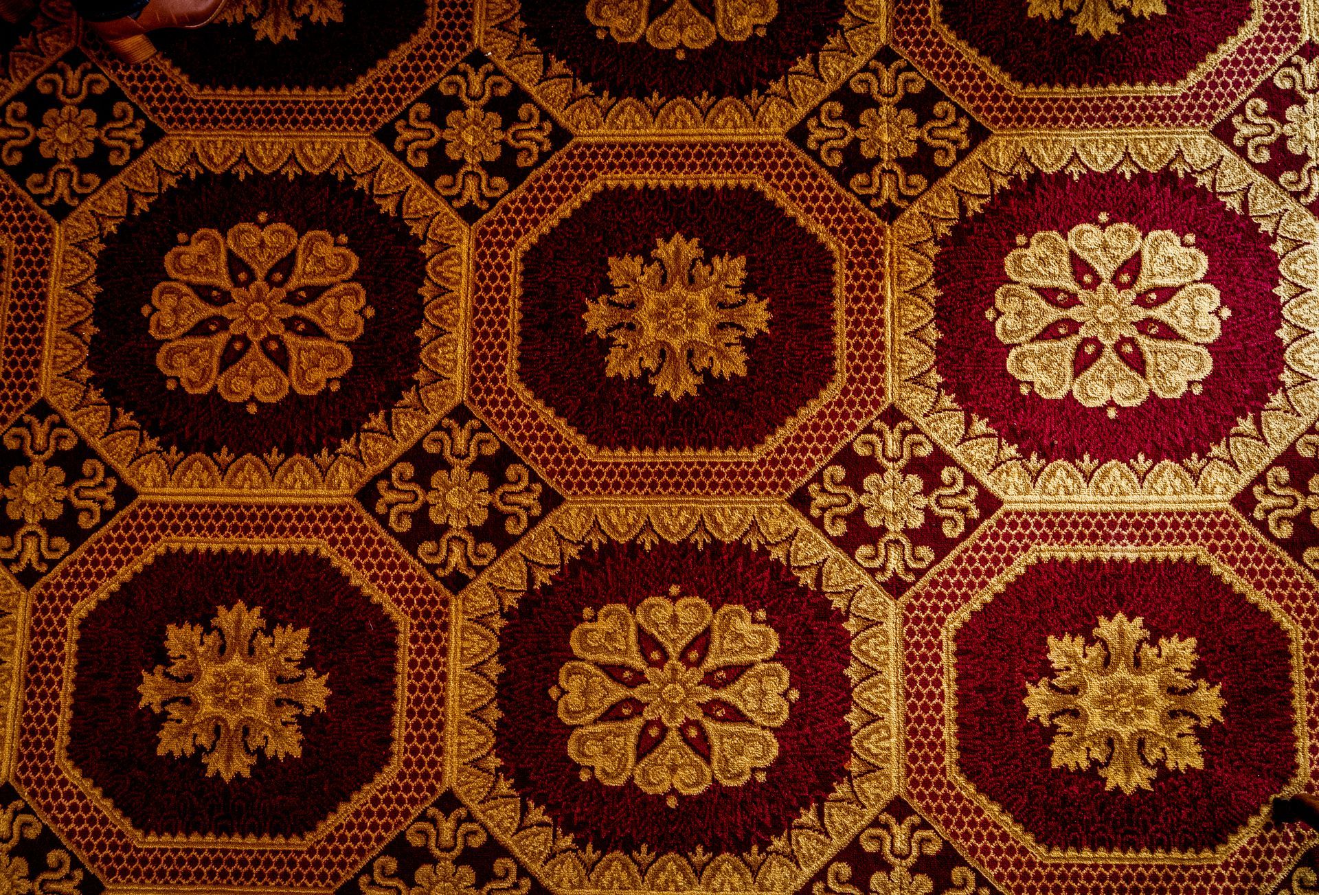 A red rug with gold flowers on it