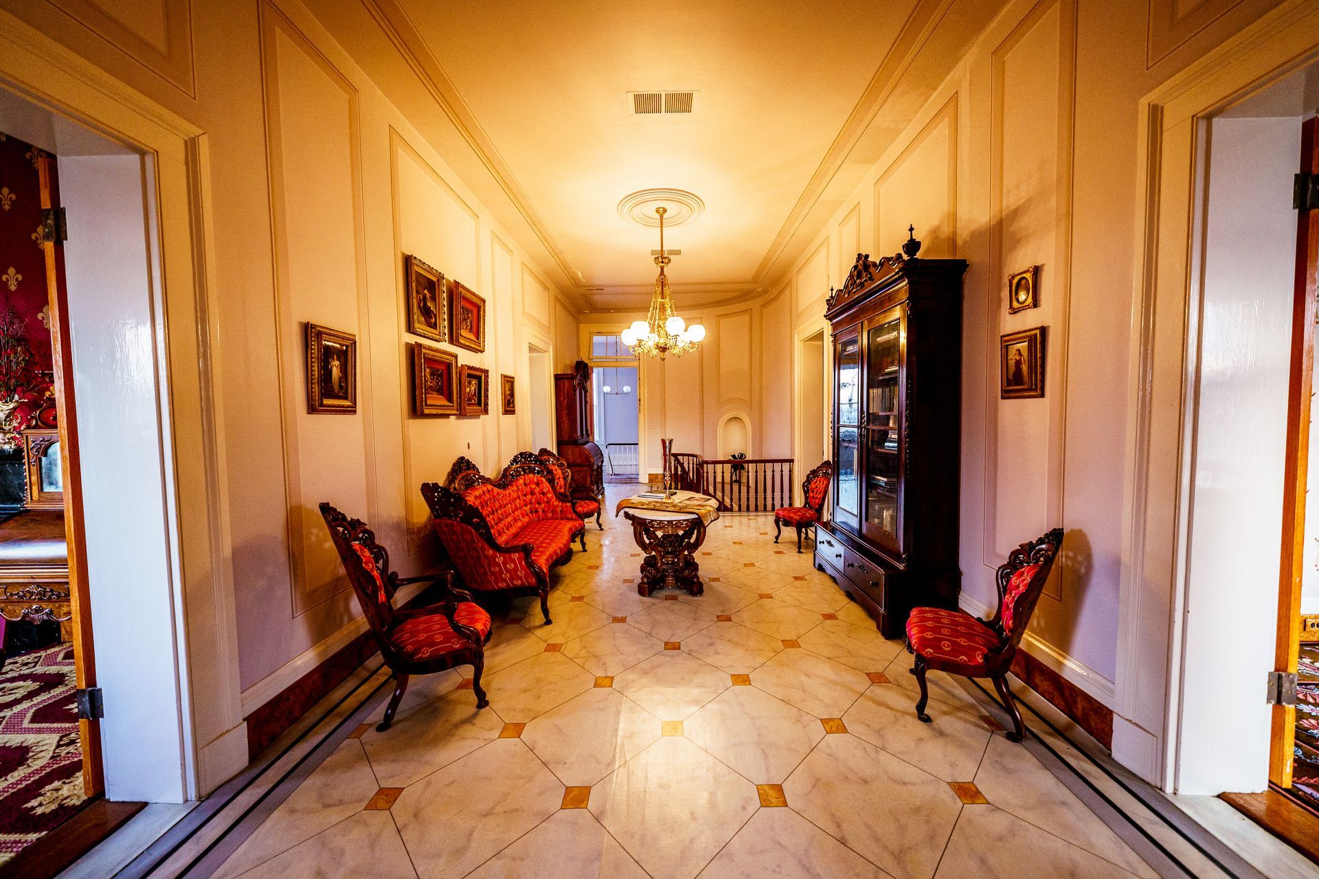A long hallway with a couch and chairs in it.