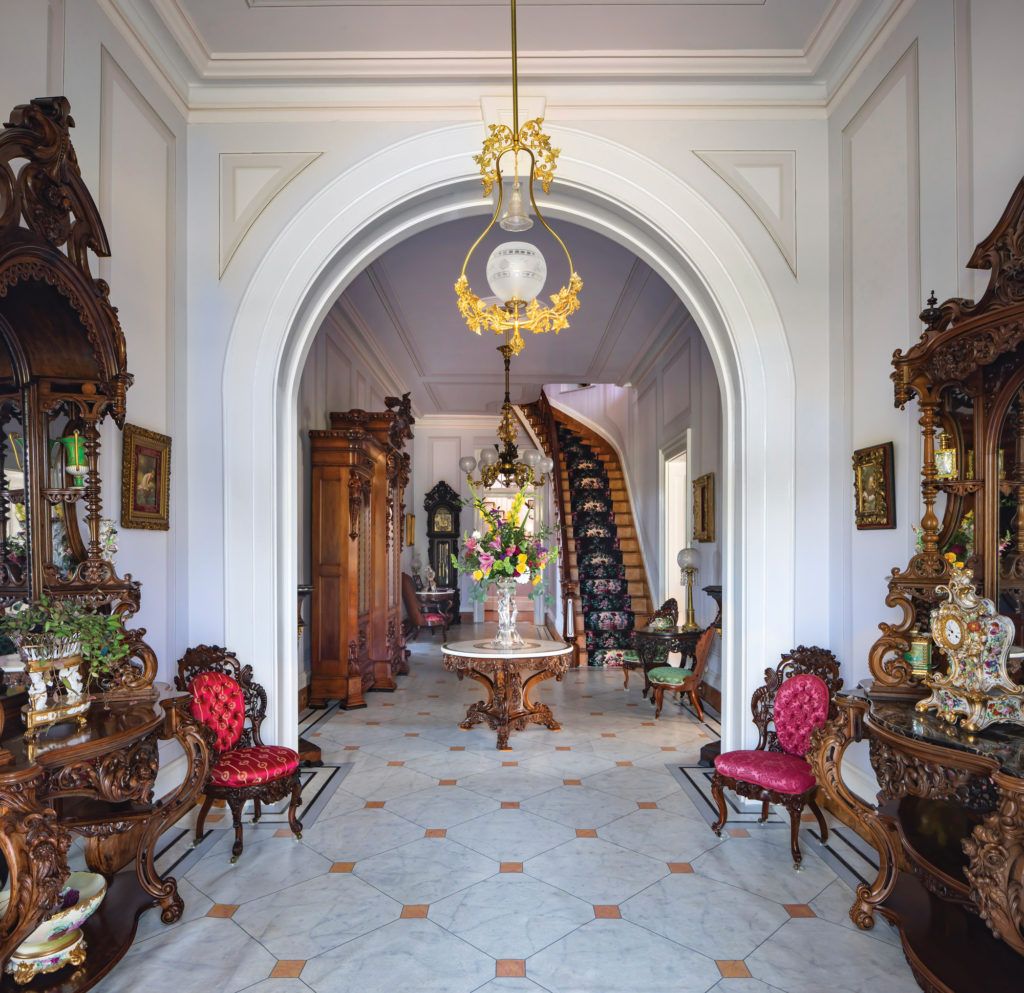 A hallway with a table and chairs and a staircase