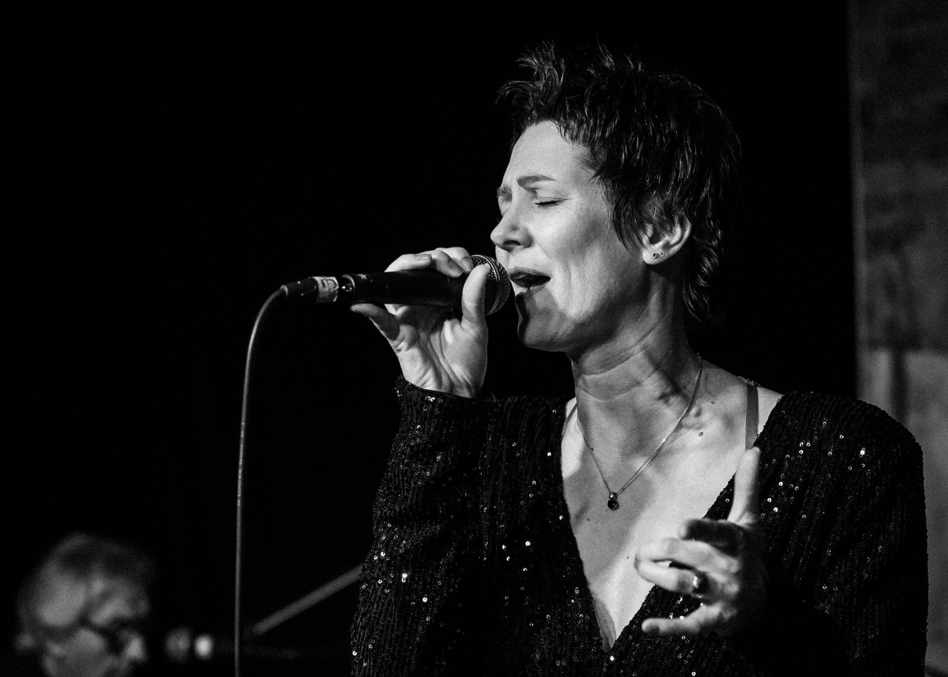 Auf einem Schwarz-Weiß-Foto singt Natalia Salamin in ein Mikrofon.