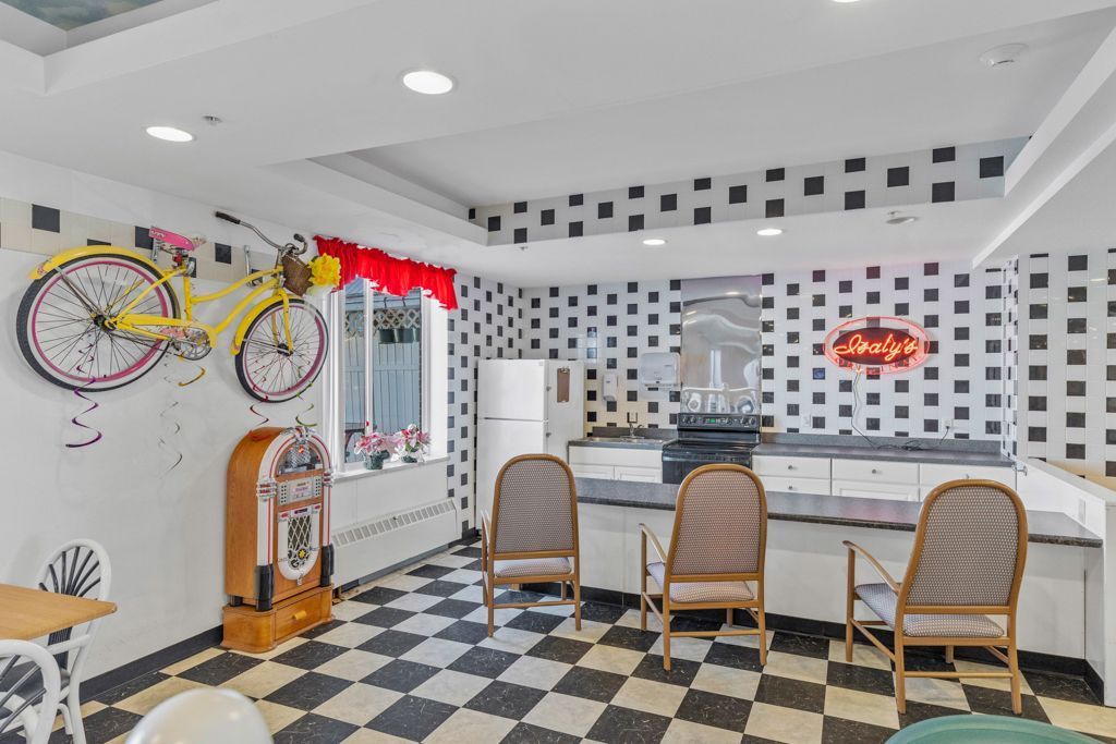 Retro diner interior with black and white checkered floor, jukebox, and bicycles.
